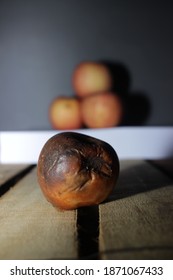 One Rotten Apple In Front Of Three Fresh Apple