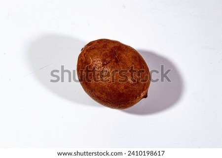 one rotten lemon is dark brown, in the photo with a plain white background