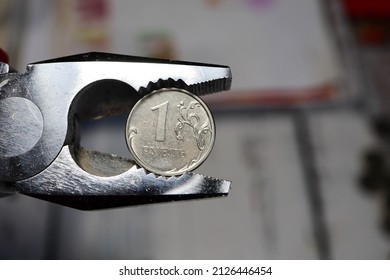 one rouble coin in pliers close up