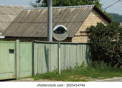 One Round Observation Mirror On A Post Outside By A Green Wooden Fence