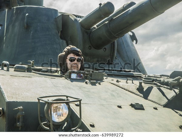 one russian warrior sit inside modern tank on\
maneuvers. Russia. soldier on the tank. man wear stylish\
sunglasses, helmet
