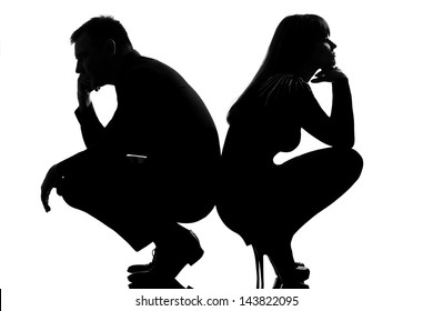 One Sad Caucasian Couple Man And Woman Crouching Back To Back In Studio Silhouette Isolated On White Background