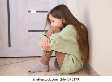 One sad girl sits on floor by door of the house. Child abuse. Anxiety and stress. Concept of bullying, depressive stress or disappointment, sadness. close-up. - Powered by Shutterstock