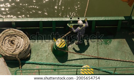 One seaman watching the mooring line during mooring of cargo ship