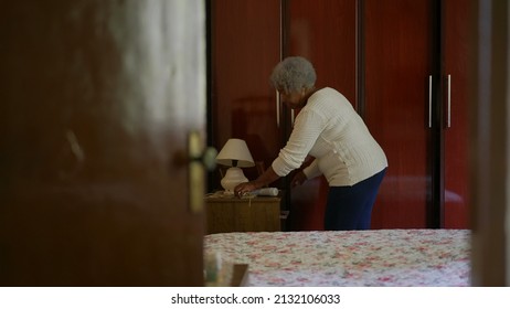 One Senior Black Woman Organizing Home In Bedroom