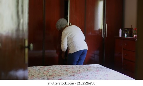 One Senior Black Woman Organizing Home In Bedroom