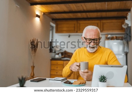 One senior man sit at home in the kitchen with cup of tea or coffee taking a brake from work or prepare for daily task morning routine real person copy space domestic life active senior