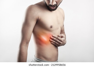 One Shirtless Male With Painful Grimace Expression On Face Touching His Thoracic Cage With Pain Highlighted In Glowing Red.