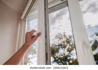 One sided open window. A hand opens a vinyl plastic window on a blue sky background.