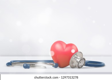 One Single Alone Red Heart Love Shape Hand Exercise Ball With Bandage MD Medical Doctor Physician's Stethoscope White Wood Background: Hospital Life Insurance Concept: World Heart Health Day Idea