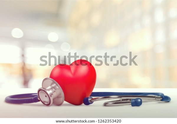 一人の赤い心臓愛の形をした手の練習用ボールと包帯md医師の聴診器の白い木の背景 病院生命保険のコンセプト 世界の心臓の健康デーのアイデア の写真素材 今すぐ編集