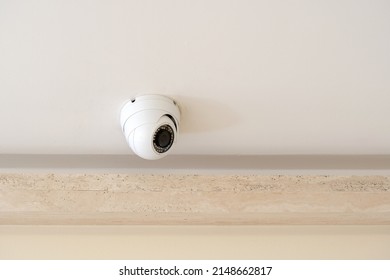 One Single Round Security Camera On A Ceiling In A Bright Room, CCTV Cam Object Detail, Closeup, Nobody. Safety, Modern Video Surveillance System, Guarding, Protection Abstract Concept, No People