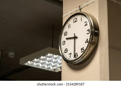 One Single Simple Industrial Clock In A Factory Hall Or A Corporate Office On The Wall. Working 9 To 5, Clocking In And Out, Time Flow, Hourly Wage Abstract Business Concept, Symbol, Nobody, No People