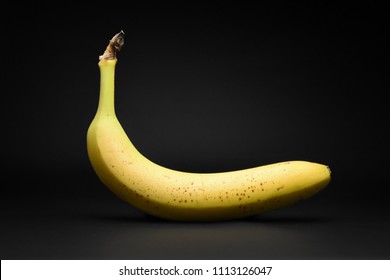 One Single Yellow Banana Isolated On Black Background