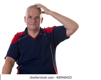 One Sitting Mature Man Wearing Blue And Red Shirt With Blank Stare Scratching His Head Over White Background