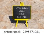 One size does not fit all symbol. Concept words One size does not fit all on black chalk blackboard on a beautiful stone background. One size does not fit all business concept. Copy space.