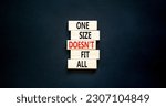 One size does not fit all symbol. Concept words One size does not fit all on wooden blocks. Beautiful black table black background. One size does not fit all business concept. Copy space.