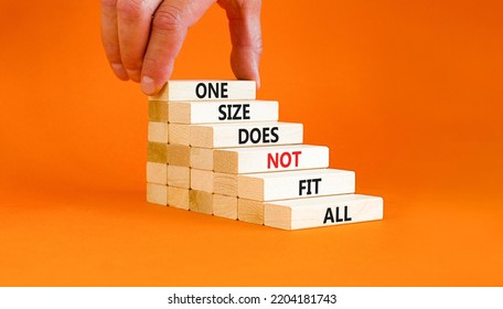 One size does not fit all symbol. Concept words One size does not fit all on wooden blocks. Businessman hand. Beautiful orange background. One size does not fit all business concept. Copy space.