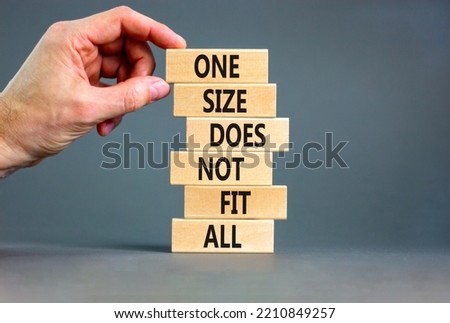 One size does not fit all symbol. Concept words One size does not fit all on wooden blocks. Businessman hand. Beautiful grey background. One size does not fit all business concept. Copy space.