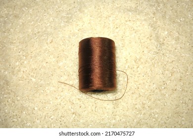 One Skein Of Brown Yarn On White Rice Grains