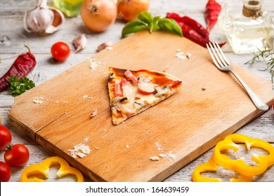 One Slice Of Pizza On Wooden Cutting Board