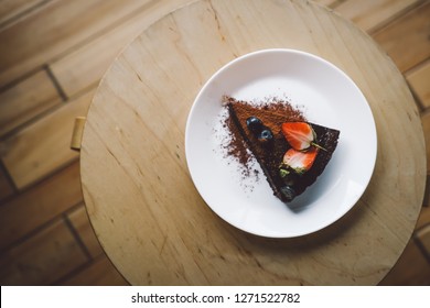 One Slice Of Vegan Raw Chocolate  Cake On Wooden Table From Above. Sugar Free, Wheat Free, Dairy Free, Flourless Dessert. Food Photo, Blog. Healthy Eating, Copyspace.