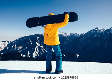 one snowboarder with snowboard on winter mountain top