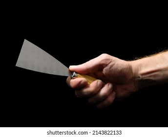 One Spatula And A Hand On A Black Background