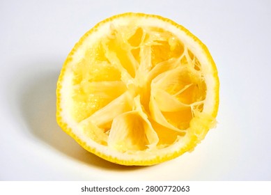 One spent lemon fruit shell after finished squeezing isolated on horizontal white background.