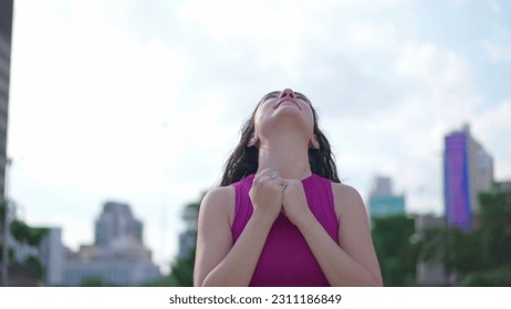 One spiritual young woman standing outdoors raising arms to sky feeling HOPE and FAITH. A joyful person looking UP feeling GRATITUDE - Shutterstock ID 2311186849
