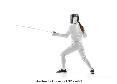 One sportsman, female fencer in white fencing costume in action, motion isolated on white background. Sport, youth, hobbies, achievements, goal. Girl practicing with rapier - Powered by Shutterstock