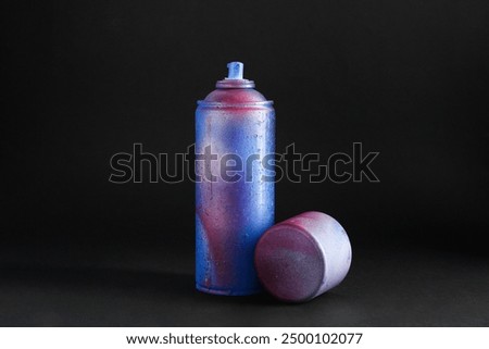 One spray paint can with cap on dark background