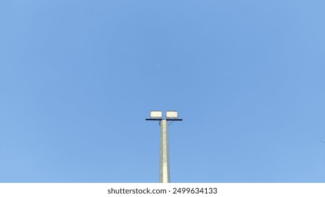 one stadium light in the middle of a sky blue background - Powered by Shutterstock