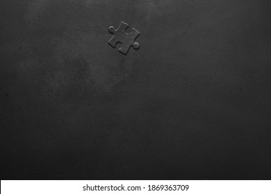 One standard small black puzzle. Photo of black puzzles on a black background, business background