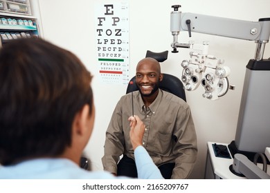 One Step Away From Better Eyesight. Shot Of A Young Man Having An Eye Test Conducted By An Optometrist.