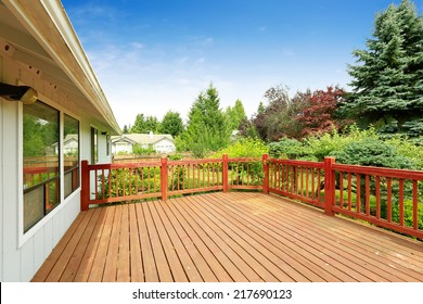 One Story House With Wooden Walkout Deck Overlooking Backyard Garden