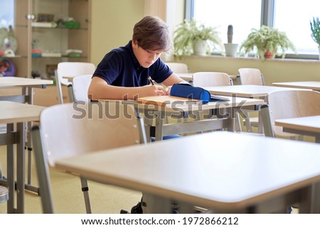 One student sitting and learning alone in empty classroom
