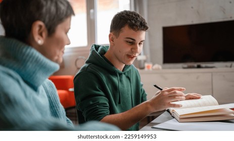 One student teenage caucasian man study learn with help of his tutor professor or mother senior woman at home having private lesson to prepare for exam education concept real people copy space - Powered by Shutterstock