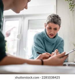 One student teenage caucasian man study learn with help of his tutor professor or mother senior woman at home having private lesson to prepare for exam education concept real people copy space - Shutterstock ID 2281038425