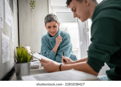 One student teenage caucasian man study learn with help of his tutor professor or mother senior woman at home having private lesson to prepare for exam education concept real people copy space - Shutterstock ID 2281038427