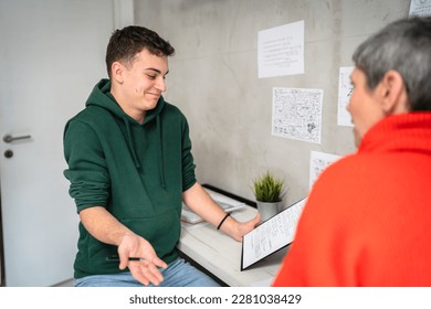 One student teenage caucasian man study learn with help of his tutor professor or mother senior woman at home having private lesson to prepare for exam education concept real people copy space - Shutterstock ID 2281038429
