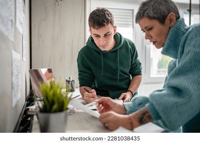 One student teenage caucasian man study learn with help of his tutor professor or mother senior woman at home having private lesson to prepare for exam education concept real people copy space - Shutterstock ID 2281038435
