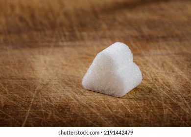 One Sugar Cube In Heart Shape Over Wooden Background With Copy Space