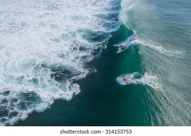 One surfer dropping in on another at Padang Padang in Bali, Indonesia