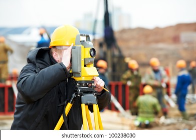 One surveyor worker working with theodolite transit equipment at construction site outdoors