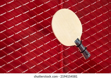 One Table Tennis Paddle Racket Is Hung On Red Grill By A Cable Tie For Display In Exhibition Sports Event