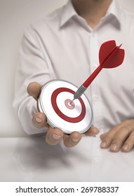 One target and a dart in man hand, symbol of accomplishment or career. White shirt - Shutterstock ID 269788337