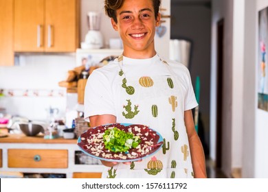 one teenager cooking at home and showing his plate with jam and vegetables - healthy lifestyle