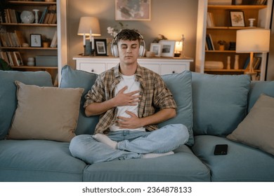 one teenager man young caucasian male use headphones for online guided meditation practice mindfulness yoga with eyes closed at home real people self care manifestation concept copy space generation Z - Shutterstock ID 2364878133