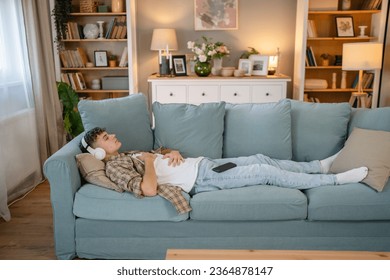 one teenager man young caucasian male use headphones for online guided meditation practice mindfulness yoga with eyes closed at home real people self care manifestation concept copy space generation Z - Shutterstock ID 2364878147